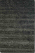 A rectangular area rug with a textured, shaggy surface featuring a dark charcoal gray and black abstract chevron pattern, shown flat against a white background.
