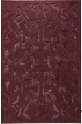 A rectangular area rug in a deep burgundy color, featuring a raised, symmetrical abstract floral or vine pattern across the surface.