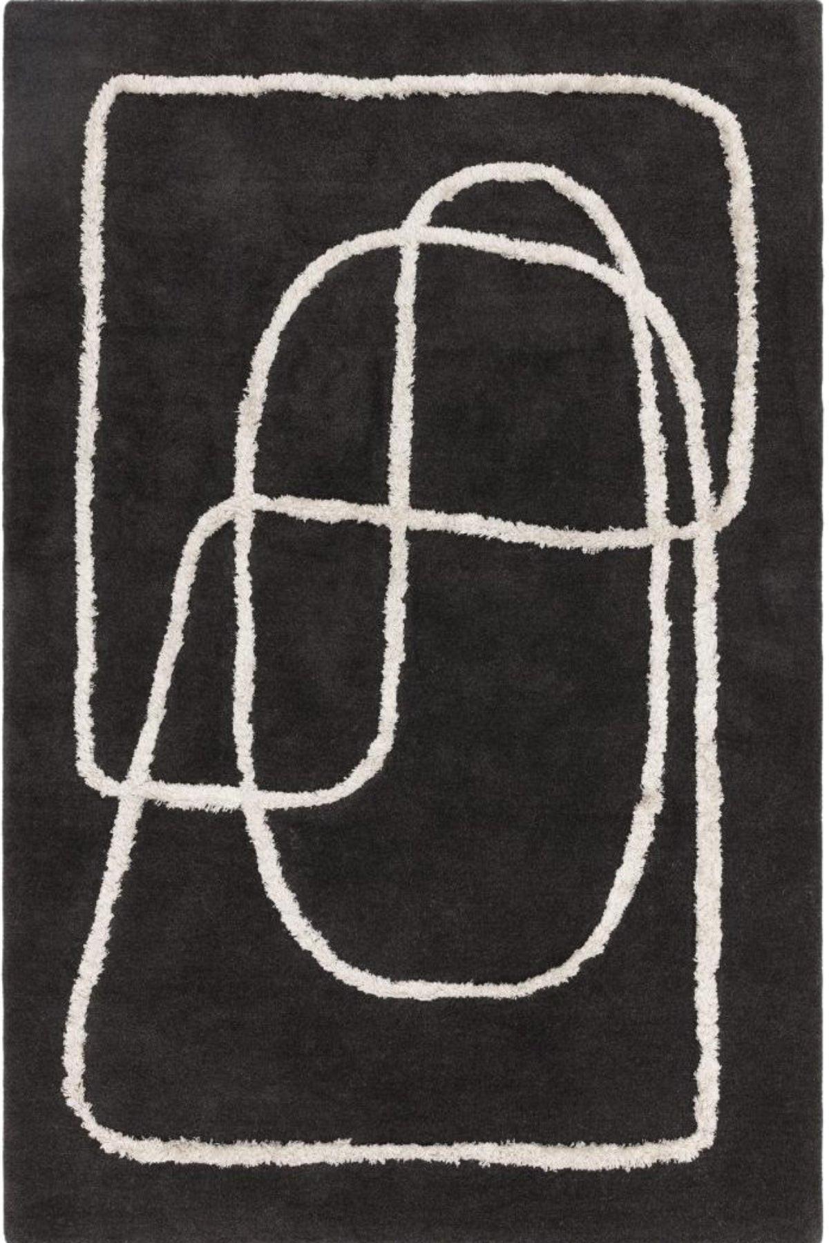 Black rug with white abstract patterns on a plain background