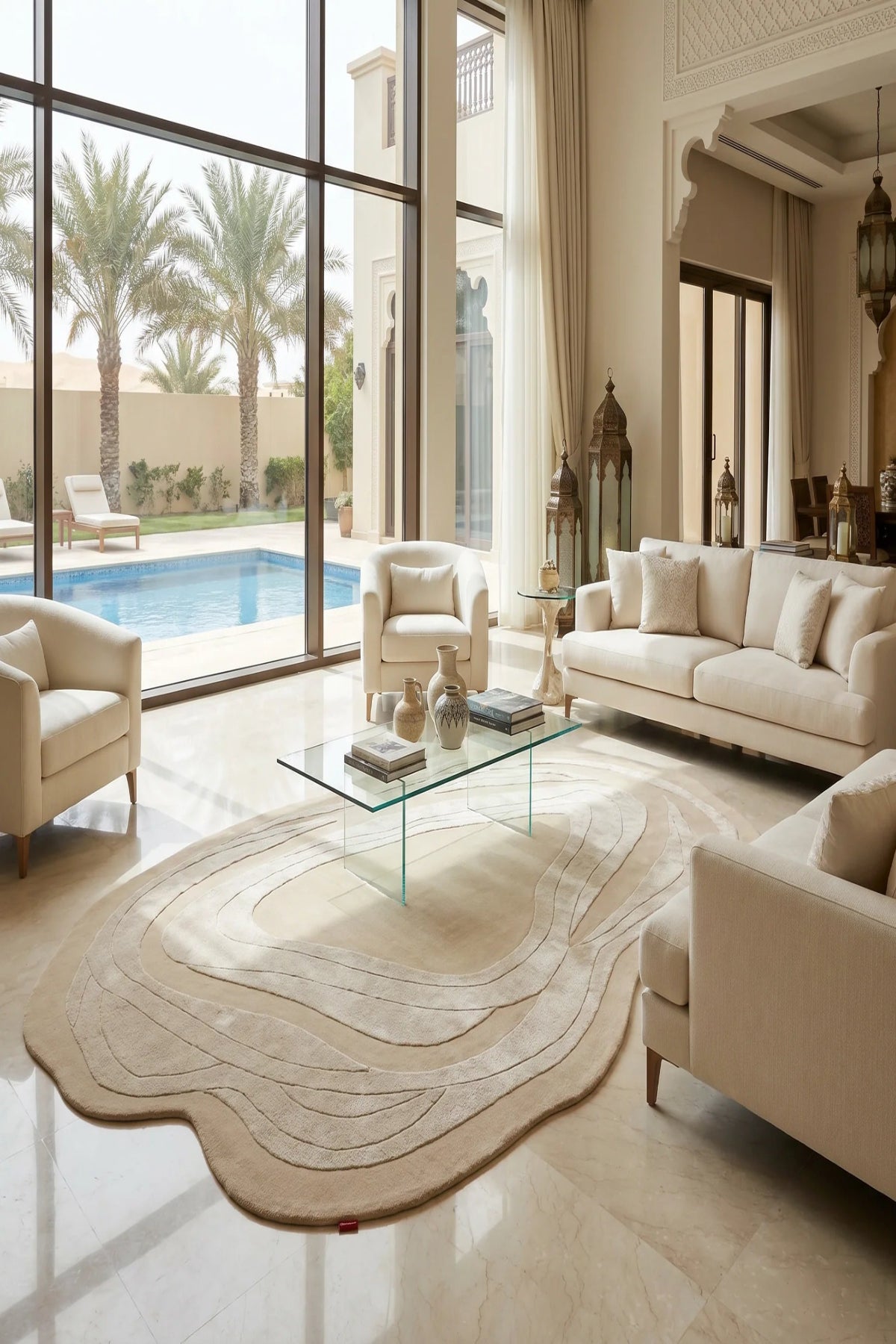 Modern living room with beige sofas, a glass coffee table, and a view of a pool.