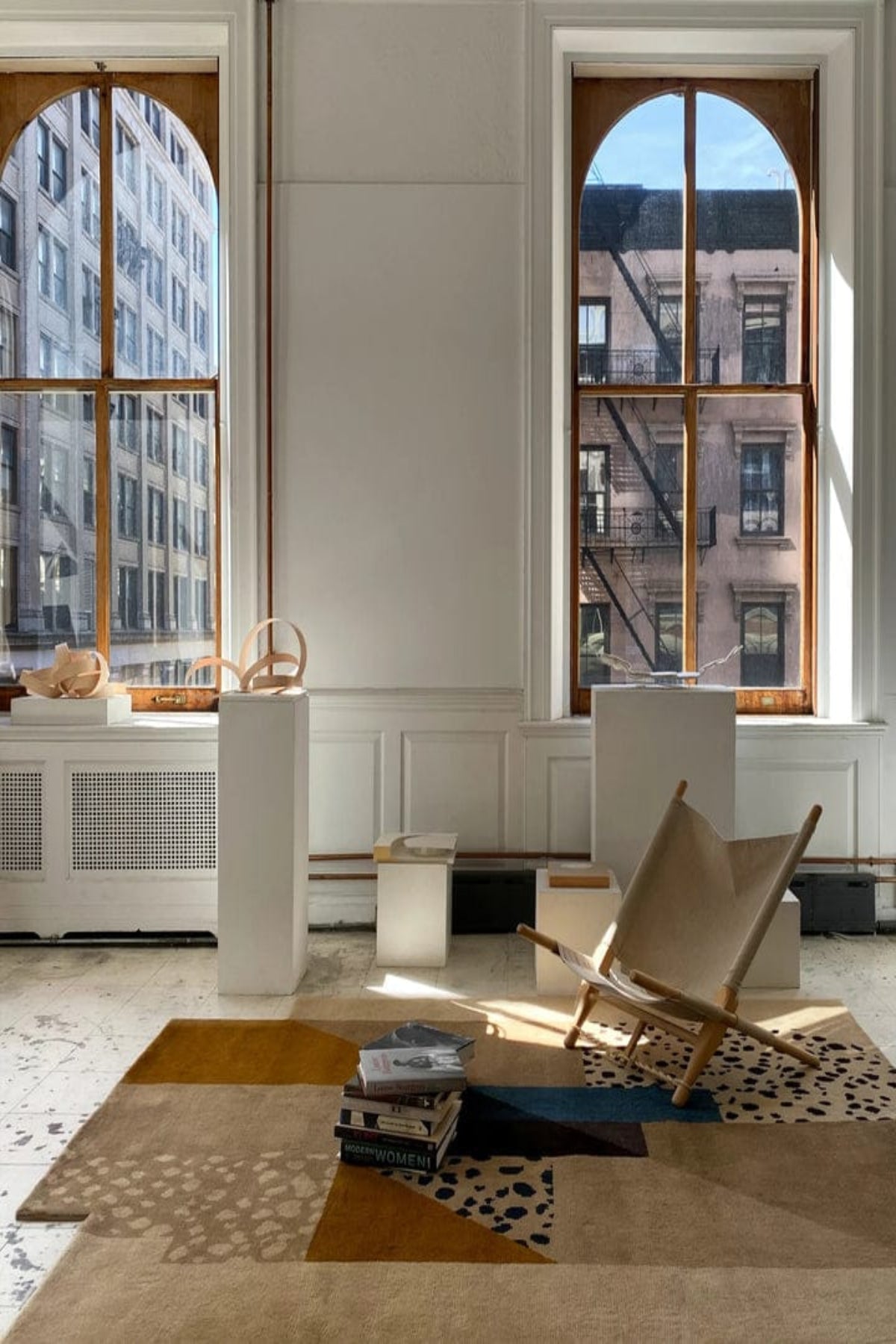 Modern interior with a chair, rug, and large windows. |NORDIC RUG | KALEENVIBE 