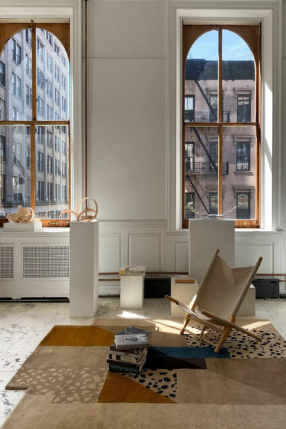 Modern interior with a chair, rug, and large windows. |NORDIC RUG | KALEENVIBE 