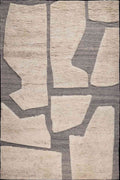 Abstract area rug with irregular beige stone-like shapes on a textured gray background.