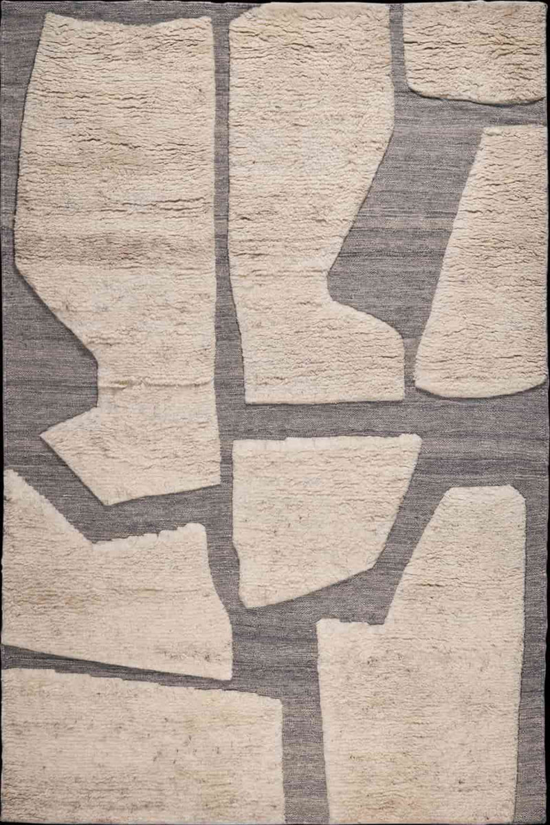 Abstract area rug with irregular beige stone-like shapes on a textured gray background.