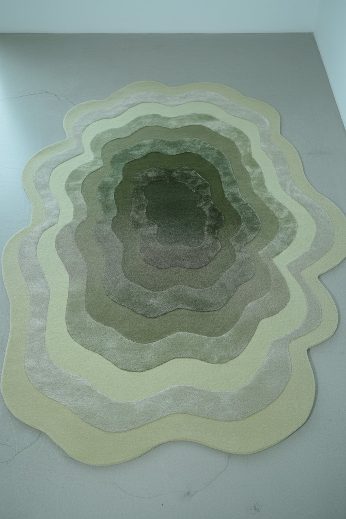Multicoloured circular rug on a light gray floor with a window and chair in the background. handmade irregular carpet